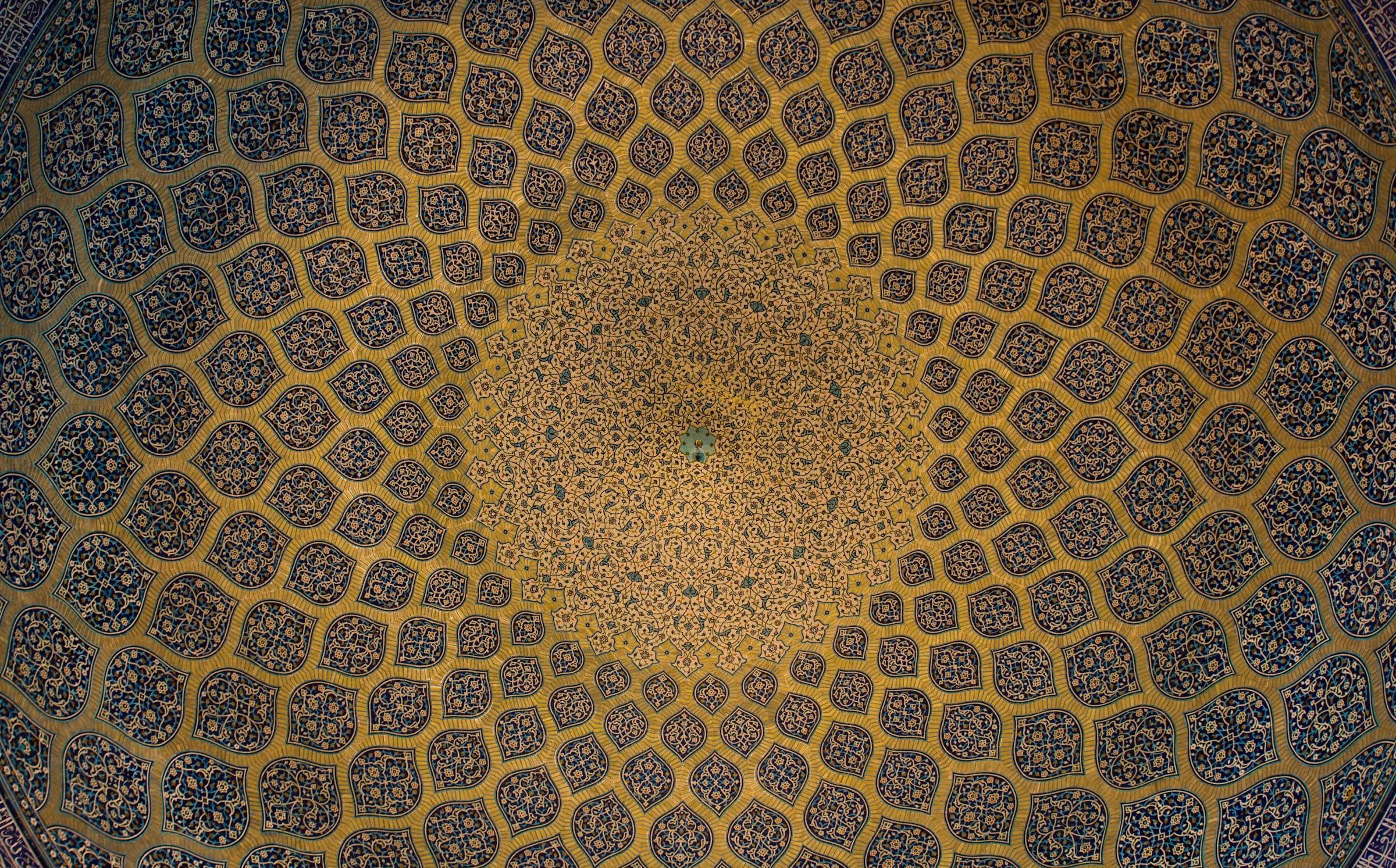 A view of the mosque ceiling in Isfahan, Iran, featuring ornate designs and colourful tiles that highlight Islamic architecture.